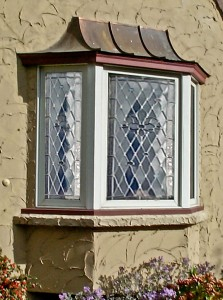 A window with stained glass on the outside of a house.